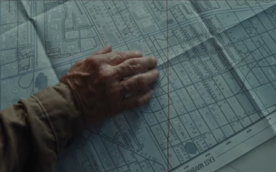 Movie still shows hand on map.