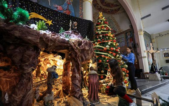 Palestinian girls decorate a Christmas tree and Nativity inside Holy Family Church in Gaza City Dec. 9, 2025, as the community prepared for modest Christmas celebrations after two years of war. (OSV News/Reuters/Dawoud Abu Alkas)