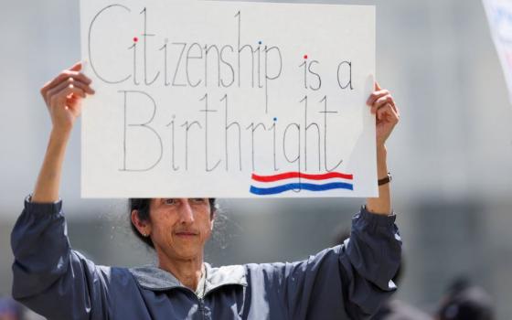 A demonstrator holds a sign as people protest on the day Supreme Court justices hear oral arguments over U.S. President Donald Trump's bid to broadly enforce his executive order to restrict automatic birthright citizenship, outside the U.S. Supreme Court in Washington May 15. (OSV News/Reuters/Leah Millis)