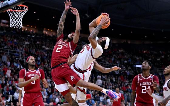 Arkansas Razorbacks guard Boogie Fland (2) and St. John's Red Storm guard Aaron Scott (0) fight for a rebound during the second half of a second round men's NCAA Tournament game at Amica Mutual Pavilion in Providence, R.I., March 22, 2025. An FBI probe has led to 26 people being charged in college basketball point-shaving scheme that allegedly bribed players to rig games, with indictments involving players and games at Catholic colleges, including St. John's. (OSV News/Reuters/Brian Fluharty-Imagn Images)