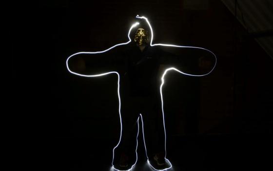 image shows person on back background, with white light outlining the body (Unsplash/Richard Sausage)
