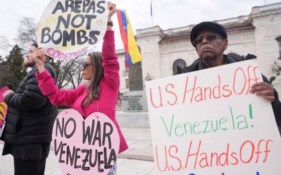 Protesters hold up signs outside the Organization of American States building Jan. 6 at the OAS in Washington. (AP/Jacquelyn Martin)
