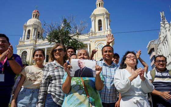 A woman holds an image of then-Cardinal Robert Francis Prevost in front of the Cathedral of St. Mary in Chiclayo, Peru, May 8, 2025, after he was elected pope at the Vatican and chose the name Leo XIV. He served as bishop of Chiclayo from 2015 to 2023. (OSV News/Reuters/Diego Torres Menchola)