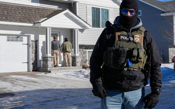 Federal agents knock on the door of a residence Jan. 28, 2026, in Blaine, Minn. (AP/Adam Gray)