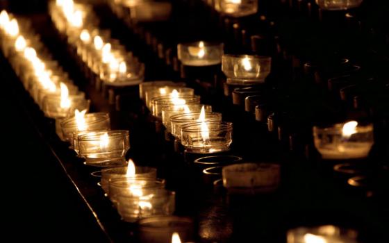 rows of lit votive candles