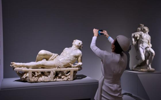 A journalist photographs San Lorenzo, left, and San Sebastiano, two juvenile marble statues by Italian Baroque master Gian Lorenzo Bernini, during the press preview of the exhibition "Bernini and the Barberini" at Palazzo Barberini in Rome on Feb. 11. (AP/Domenico Stinellis)