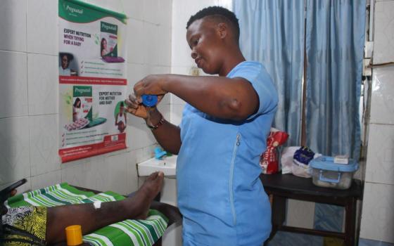 Gladys Madukwe, a nurse-midwife and member of the community advocacy team, dresses a patient's wound in the treatment room at Ancilla Catholic Hospital in Lagos, Nigeria. The hospital is run by the Sisters of the Handmaids of the Holy Child Jesus. (Valentine Benjamin)
