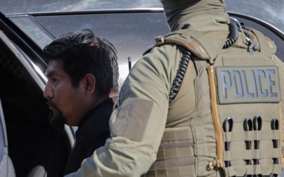 An agent with U.S. Immigration and Customs Enforcement, or ICE, detains a man during an immigration raid in Thermal, Calif., Dec.19, 2025. (OSV News/Reuters/Daniel Cole)