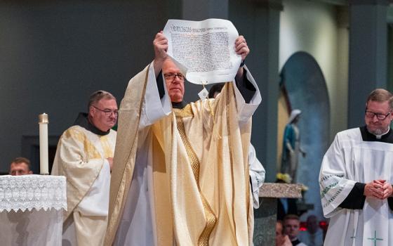 Bishop Michael Martin displays the papal bull from Pope Francis appointing him to head the Diocese of Charlotte, N.C., during his ordination and installation Mass at St. Mark Church in Huntersville, N.C., May 29, 2024. (OSV News/Catholic News Herald/Troy Hull)