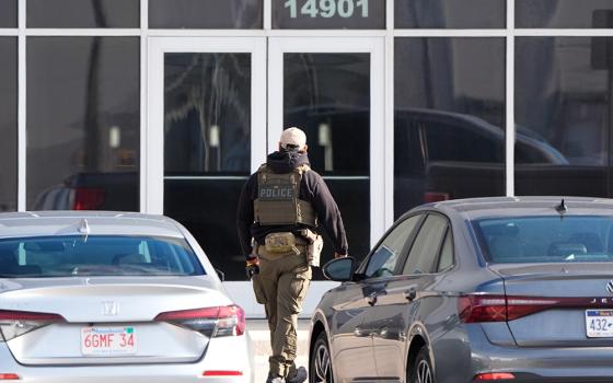 An ICE agent stands outside a warehouse as federal officials tour the facility to consider repurposing it as an ICE detention facility, Jan. 15, 2026, in Kansas City, Missouri. (AP photo/Charlie Riedel)