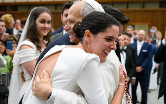 Pope Leo XIV embraces a newly married couple at the conclusion of his weekly general audience in the Paul VI Audience Hall at the Vatican Aug. 27, 2025. Leo announced March 19, 2026, that he is asking the presidents of all bishops' conferences around the world to convene in Rome in October to renew and deepen the Church's discussion on marriage and family in light of Amoris Laetitia. (CNS/Vatican Media)