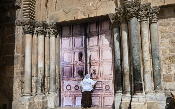 An Ethiopian Christian woman prays before the closed doors of the Church of the Holy Sepulchre in the Old City of Jerusalem on March 4, 2026, the fifth day of the war between the United States and Israel against Iran. 