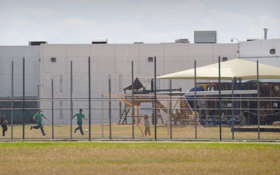 Children are pictured in a file photo playing in a double-fenced playground area outside the T. Don Hutto Family Residential Facility, an ICE detention center operated by CoreCivic, in Taylor, Texas. (OSV News/Bahram Mark Sobhani)