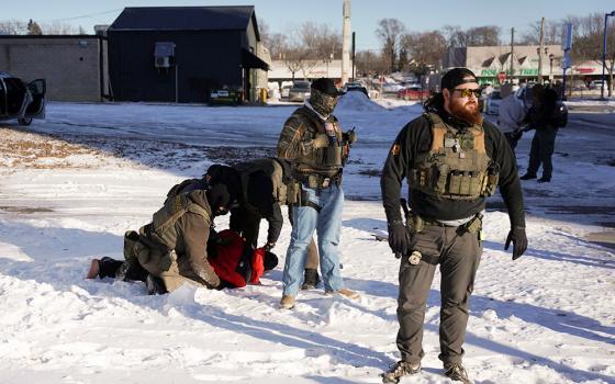 Agents with U.S. Immigration and Customs Enforcement, or ICE, detain a man as they conduct an immigration enforcement action in St. Paul, Minn., Jan 27, 2026. (OSV News/Reuters/Seth Herald)
