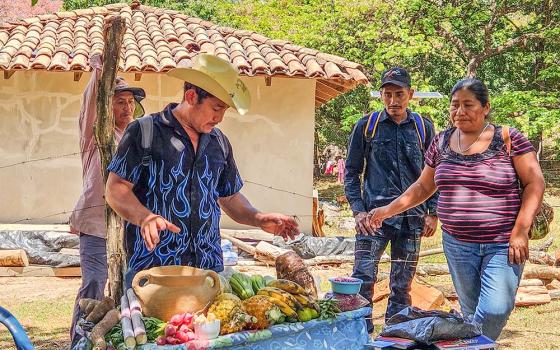 Desiderio Vasquez, a local farmer, shows off a colorful cornucopia of the bounty cultivated and grown partly through a series of irrigation systems the community of Los Hornos, Honduras, built with the help of Catholic Relief Services and local partners. (NCR photo/Brian Roewe)