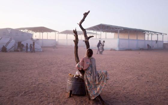 A Sudanese refugee girl from al-Fashir, Sudan, rests next to a burnt tree in the middle of the Tine transit camp in eastern Chad, Nov. 23, 2025, amid the conflict in Sudan between the paramilitary Rapid Support Forces and the Sudanese army. (OSV News/Reuters/Amr Abdallah Dalsh)