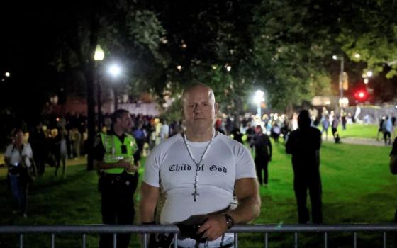 A man wearing a rosary and T-shirt reading "Child of God" attends a prayer vigil for conservative activist Charlie Kirk in Boston Sept. 18, 2025. Kirk, co-founder of Turning Point USA, was fatally shot Sept. 10 during an event at Utah Valley University in Orem. (OSV News photo/Reuters/Brian Snyder)