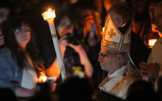 Pope Leo XIV carries a candle as he arrives to celebrate the Easter Vigil in St. Peter's Basilica at the Vatican April 4. (CNS/Lola Gomez)
