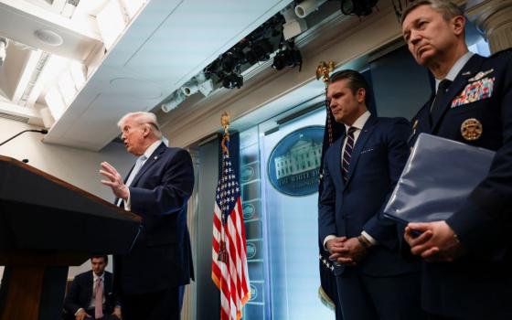 U.S. President Donald Trump answers questions from the media during a news conference about Iran April 6. Secretary of Defense Pete Hegseth and Chairman of the Joint Chiefs of Staff Gen. Dan Caine listen as he speaks. (OSV News/Reuters/Evelyn Hockstein)