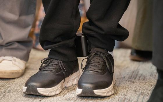 Dylan Lopez Contreras wears an ankle monitor during a press conference to welcome him home after being freed from ICE detention, March 19, 2026 in New York. Catholics in Harrisburg, Pennsylvania, are wearing faux ankle monitors in solidarity with migrants. (AP photo/Adam Gray)