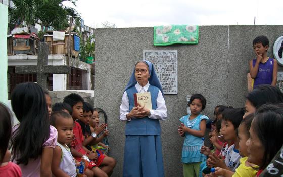 Sr. Evangelina Canag teaches Bible lessons to children living inside a public cemetery in Manila in 2008. (Courtesy of Daughters of St. Paul)