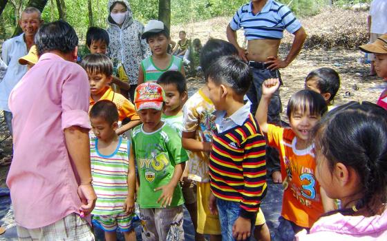 Parents watch their children with autism play games during a beach trip organized by the Lovers of the Holy Cross sisters in Vietnam on Sept. 13, 2025. (Joachim Pham)