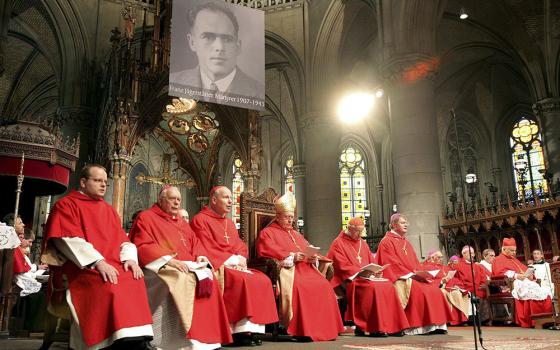 A portrait of Blessed Franz Jägerstätter hangs in St. Mary's Cathedral during his beatification in Linz, Austria, Oct. 26, 2007. Cardinal Jose Saraiva Martins, seated at far right, presided at the ceremony. (CNS/Reuters) 