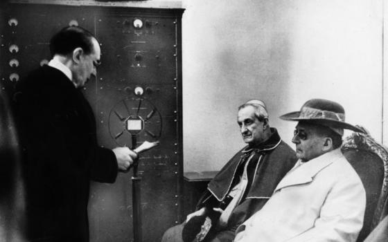 Pope Pius XI, founder of Vatican Radio, right, listens to the address of Guglielmo Marconi, the inventor of radio, during a 1933 ceremony inaugurating the world's first station for radio communication by ultrashort wave. In "Quadragesimo Anno," Pius lamented the "economic dictatorship" the Industrial Revolution created. (CNS) 