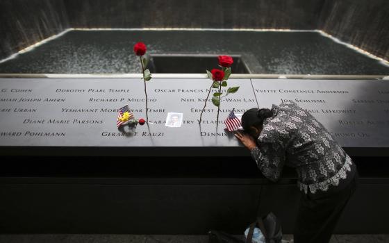 A woman grieves at the inscription of her late husband's name at the national 9/11 Memorial and Museum in New York City Sept. 11, 2014. (OSV News/Reuters/Chang Lee)