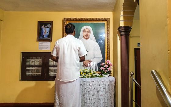 A man prays before a portrait of Venerable Sr. Maria Celine Kannanaikal at the  provincial house of the Ursulines of Mary Immaculate in Payyambalam, a suburb of Kannur town in the southwestern Indian state of Kerala. (George Kommattam)