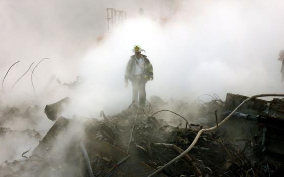 A firefighter walks amongst the rubble and the smoldering wreckage of the World Trade Center Oct. 11, 2001, in New York. (AP/Gary Friedman, pool)