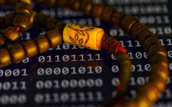 Prayer beads are photographed over a screen displaying binary code in Phoenix, Friday May 8, 2026. (AP photo/Dario Lopez-Mills)