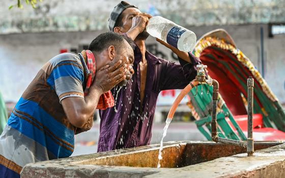 A rickshaw driver washes his face at a roadside water pipeline during a heat wave in Dhaka, Bangladesh, April 27, 2024. (Dreamstime/Mamunur Rashid)