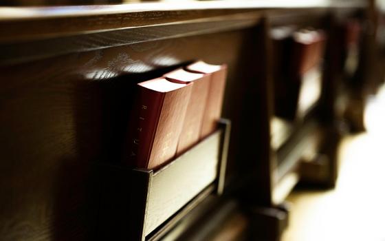 Pews with hymnals (Unsplash/Gianna B)