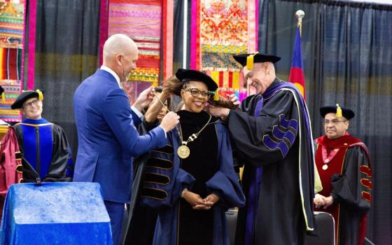 Derek Scarth, chair of Regis University's board of trustees, and Jesuit Fr. Tom Curran, superior of the Regis University Jesuit House, place the presidential medallion on Shawna Cooper Whitehead during her Sept. 18, 2026, inauguration in Denver as Regis' 29th president. (OSV News/Courtesy of Regis University)