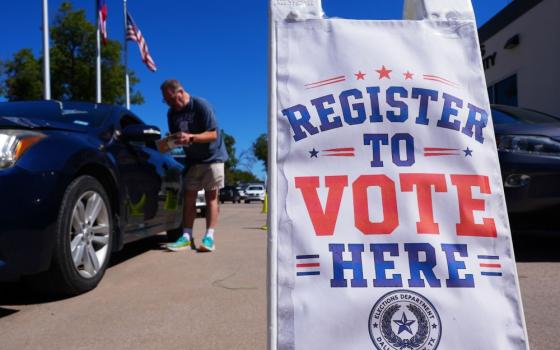 Volunteer Steven Marlin, left, helps a driver register to vote at a drive up location outside the Dallas CounElections Department in Dallas Monday, Oct. 5, 2026. (AP/LM Otero)