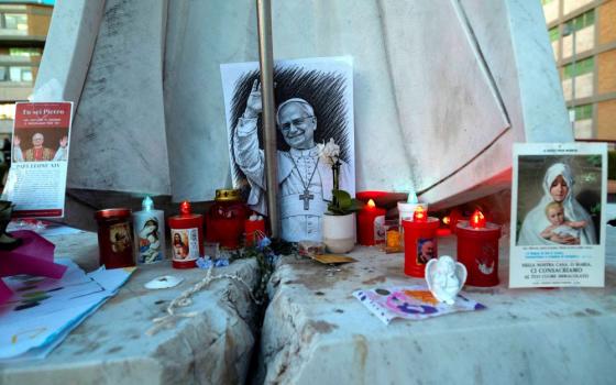 Images of Pope Leo XIV and other objects are displayed at the base of the statue of St. John Paul II outside Rome's Gemelli Hospital Oct. 15, 2026. (OSV News/Reuters/Remo Casilli)