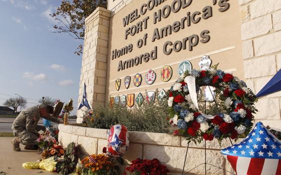 United States Army Specialist Robert Orcutt prays near a makeshift memorial for victims of the shootings at Fort Hood Army post in Fort Hood, Texas, Nov. 9, 2009. (OSV News photo/Jessica Rinaldi, Reuters) 