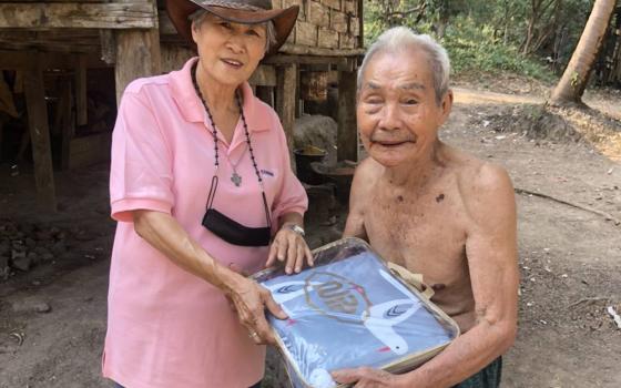 Presentation Sr. Cecilia Phetpanomporn gives blankets to a refugee at a camp on the border between Thailand and Myanmar. (Courtesy of Good Shepherd International Foundation)