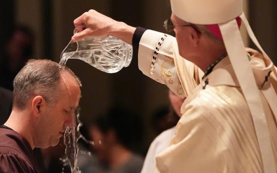 Archbishop Paul D. Etienne baptizes a candidate during an Easter Vigil service at St. James Cathedral, Saturday, April 4, 2026, in Seattle. (AP Photo/Lindsey Wasson)