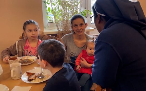Sr. Ligi Payyappilly converses with women and children at the breakfast table in her convent in Mukachevo, western Ukraine. (Courtesy of Ligi Payyappilly)