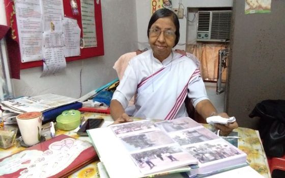 Sr. Judith Meckado of the Franciscan Missionaries of Christ the King displays a photo album with pictures of "A Pilgrimage of the Heart" at her office in Old Goa, western India. (Lissy Maruthanakuzhy)