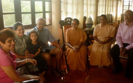 Sr. Jyothi Kerketta and Sr. Celine Sebastian of the Daughters of St. Paul converse with a family in the Fontainhas neighborhood of Panjim India. (Lissy Maruthanakuzhy)