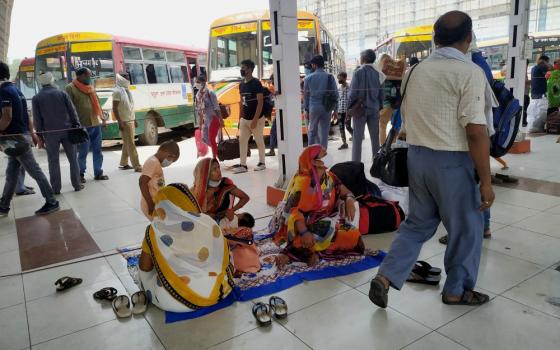 Mothers and children wait at Kaushambi Bus Terminal on the Delhi-Uttar Pradesh border to go to their villages in eastern India hundreds of kilometers away. (Jessy Joseph)