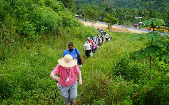 A 24-person delegation to Honduras organized by the SHARE Foundation begins to climb up a hillside to visit with the El Aguacate community.