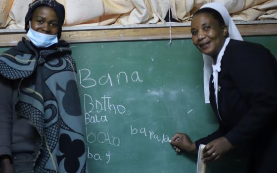 Sr. Amelia Dikiso, a member of the Good Shepherd Sisters of Quebec, teaches a herd boy how to put letters together to form words at the Good Shepherd Night School in Semonkong, Lesotho. (GSR photo/Doreen Ajiambo) 
