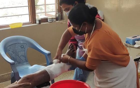 Sr. Fathima Mary Lourdraj bandages a patient at Sumanahalli's clinic in Bengaluru, India. The main charism of her order, the Franciscan Sisters of the Immaculate, is to serve those afflicted with leprosy. (Thomas Scaria)