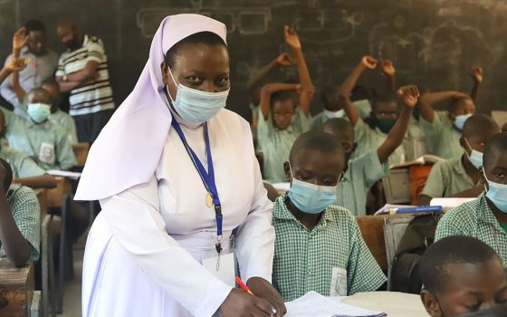Sr. Anne Onyancha helps a boy with his studies at St. Peter's Mumias Boys Primary School in Kakamega, Kenya. (GSR photo/Doreen Ajiambo)