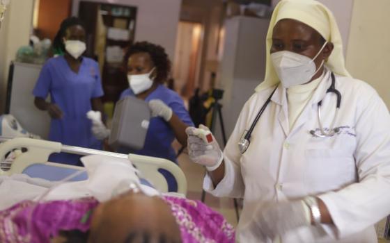 Sr. Assumpta Nabawanuka attends to a patient at St. Francis Hospital Nsambya in Kampala, Uganda's capital.