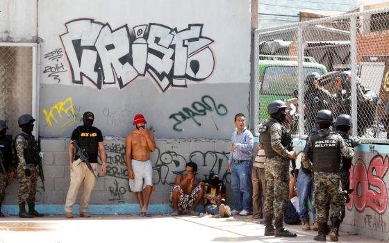 Military police in Tegucigalpa, Honduras, keep watch on suspected MS-13 gang members in this 2016 photo. (CNS/Reuters/Jorge Cabrera)